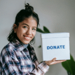 Eine weiblich gelesene Person hält eine Spendenbox