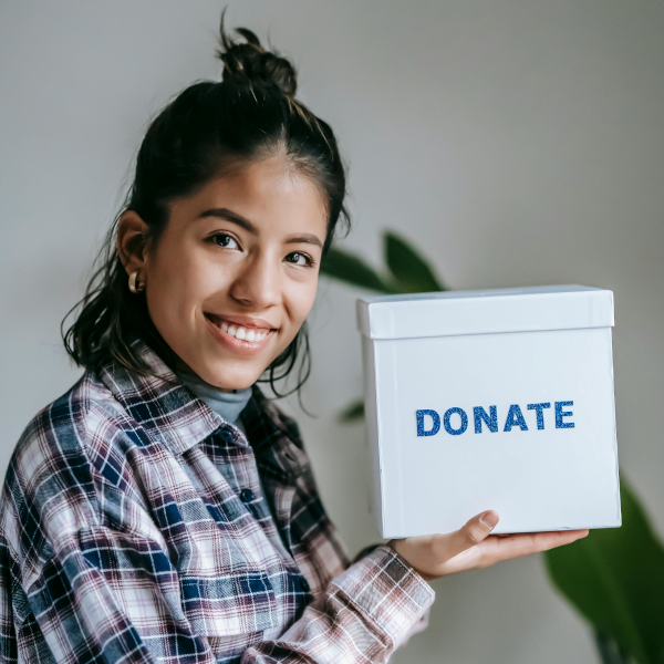 Eine weiblich gelesene Person hält eine Spendenbox
