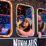 eine junge frau sitzt in einer Weihnachtsbahn auf der Nikolaus steht
