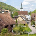 Wunderschöne Dorfansicht mit Kirche, Häusern und üppigem Grün in einer frühlingshaften Kulisse.