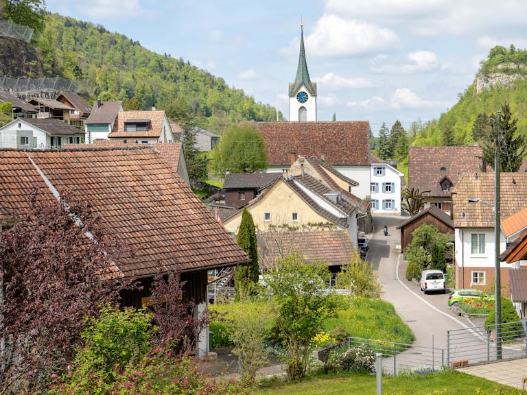 Wunderschöne Dorfansicht mit Kirche, Häusern und üppigem Grün in einer frühlingshaften Kulisse.