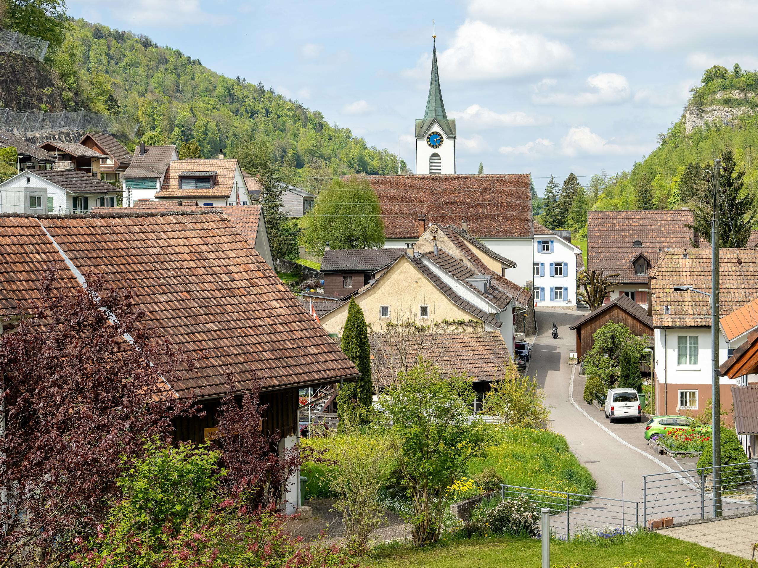 Wunderschöne Dorfansicht mit Kirche, Häusern und üppigem Grün in einer frühlingshaften Kulisse.
